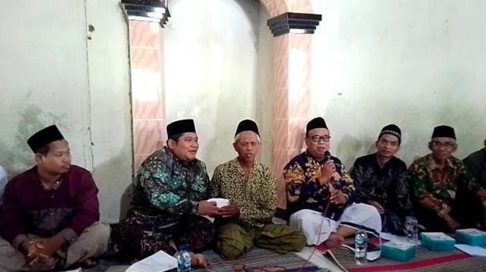 GURU DIDENDA WALIMURID - Ahmad Zuhdi (tengah) saat menerima bantuan uang dari Ketua DPRD Kabupaten Demak, Zayinul Fata dalam konferensi pers di Mushola Madrasah Diniyah Roudhotul Mutaalimin Desa Jatirejo, Kecamatan Karanganyar, Kabupaten Demak, Jumat (18/7/2025) sore.