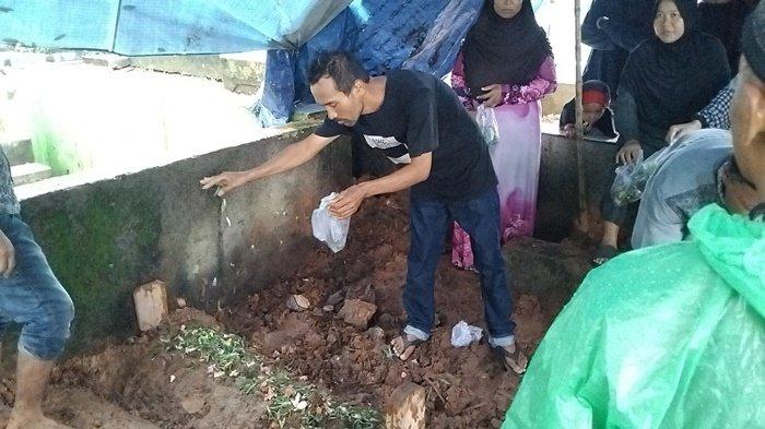 Anung Kurniawan menabur bunga dimakam anak dan istrinya di TPU Puncak Sekuning Palembang, Selasa (16/4/2024).