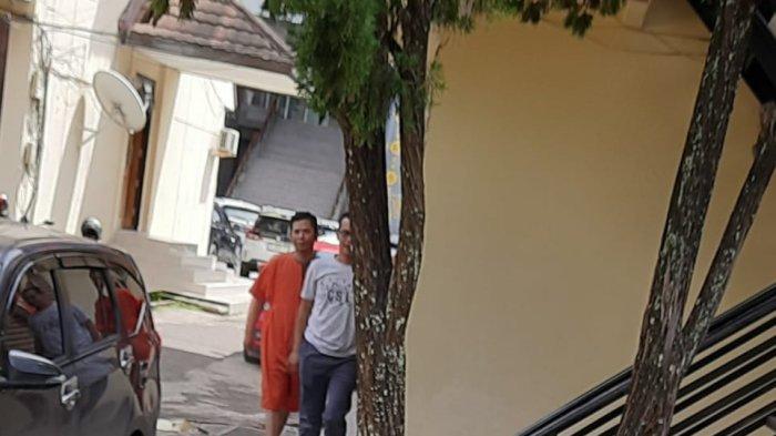 DIAMANKAN - Pelaku saat diamankan dan digiring oleh anggota Subdit III Jatanras Polda Sumsel, IS mengenakan baju oranye.