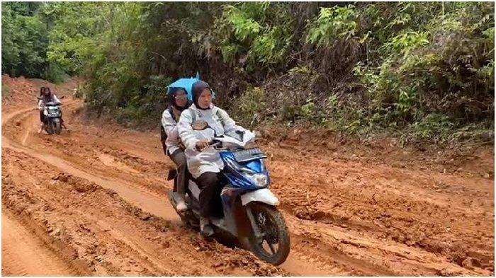 Guru SDN 18 Penukal di Talang Kukuy Dusun 3 Desa Sungai Langan saat menuju ke sekolah. Seringkali karena kondisi jalan berlumpur mereka akhirnya memutuskan jalan kaki menuju sekolah.