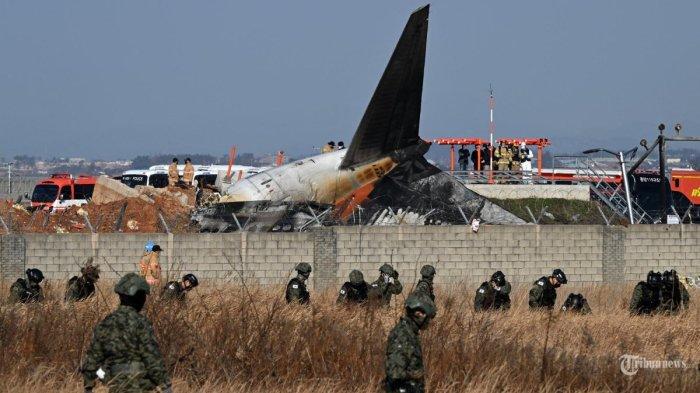 Tentara Korea Selatan mencari penumpang yang hilang di dekat puing-puing pesawat seri Boeing 737-800 Jeju Air setelah pesawat itu jatuh dan terbakar di Bandara Internasional Muan di Provinsi Jeolla Selatan, sekitar 288 kilometer barat daya Seoul pada 29 Desember 2024. Hanya dua penumpang selamat dalam kecelakaan Pesawat Jeju Air jatuh di Bandara Internasional Muan, Korea Selatan, Minggu (29/12/2024).