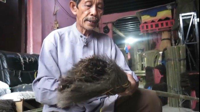 KISAH INSPIRATIF - Herman saat membuat sapu ijuk yang sudah bertahun-tahun jadi tumpuannya mencari nafkahm Selasa (6/5/2025). Herman adalah segelintis penjual sapu ijuk di Palembang yang masih bertahan. 