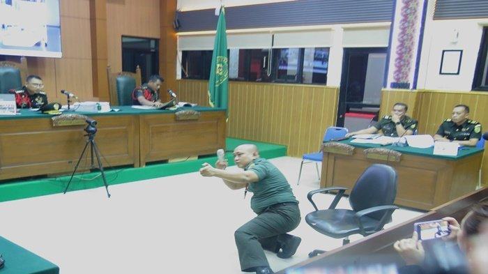 TERDAKWA -- Kopda Bazarsah memperagakan saat ia menembak tiga orang polisi Polres Way Kanan dan Polsek Negara Batin di persidangan Pengadilan Militer I-04 sebagai terdakwa, Senin (14/7/2025). Saat menembak korban terdakwa dengan posisi menjauh sambil mundur hingga setengah berdiri.