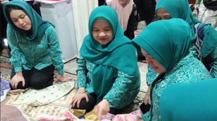 Pj Ketua TP PKK Provinsi Sumatera Selatan Melza Ayu Rahminia (tengah), didampingi Ketua TP PKK Kabupaten Ogan Ilir Mikhailia Tikha Alamsjah (kiri) saat memilih songket pewarna alam hasil produksi Elita Songket pada Selasa (30/7/2024) lalu. 