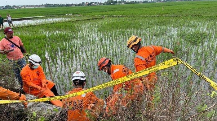 MAYAT PRIA TANPA KEPALA- Petugas BPBD saat mengevakuasi mayat pria tanpa kepala dan tak berbusana di irigasi persawahan, Jombang, Rabu (12/2/2025). Polisi berhasil mengidentifikasi jasad pria tanpa kepala yang ditemukan di saluran irigasi area persawahan Desa Dukuharum, Kecamatan Megaluh, Jombang