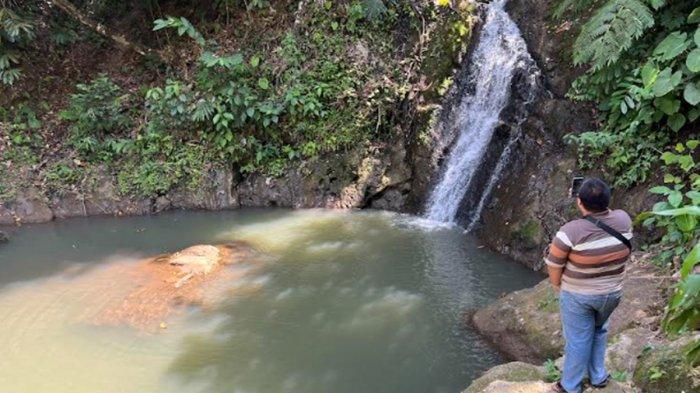 Seorang pengunjung sedang mengambil video di lokasi Air Terjun Taman Jodoh Desa Kemang Manis, Kabupaten Empat Lawang.