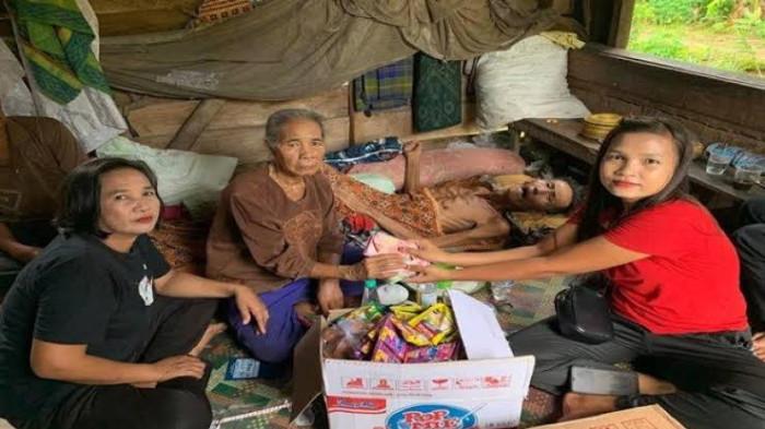 BERIKAN BANTUAN - Lilie (kanan) saat memberikan bantuan kepada warga tidak mampu yang mengalami sakit, Senin (6/1/2025). Konten kreator asal Ogan Ilir ini kembali viral setelah membandingkan pendapatan FB Pro dengan gaji TNI