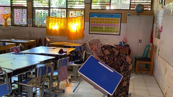 ORANG TUA MURID GANTI RUGI KURSI SEKOLAH - Arta Grace, orang tua murid saat membawa kursi ke Sekolah Dasar (SD) Negeri 2 Pasir Tangkil, Kecamatan Warunggunung, Kabupaten Lebak gegara anaknya dituding rusak meja dan kursi sekolah, Senin, (28/4/2025).