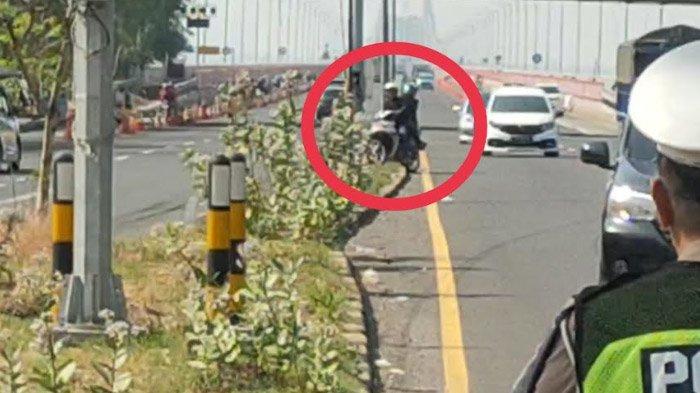 Perilaku berbahaya dari pengendara sepeda menerabas median jalan untuk menghindari razia pelanggar pemotor masuk jalur mobil yang digelar di pintu keluar Jembatan Suramadu sisi Bangkalan, Selasa (14/11/2023).