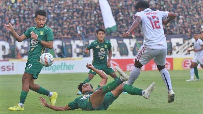 Bek sayap Persebaya Surabaya, Arief Catur (tengah), berjibaku dengan pemain Arema FC di Stadion GBT (23/9/2023).