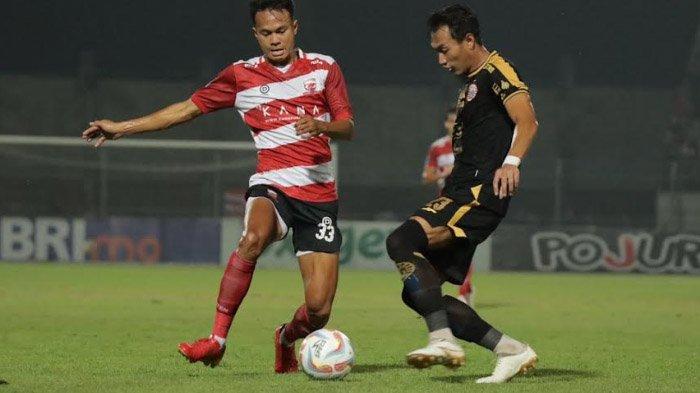 Pemain Madura United, Koko Ari Araya berduel dengan pemain Persija, Hansamu Yama.
