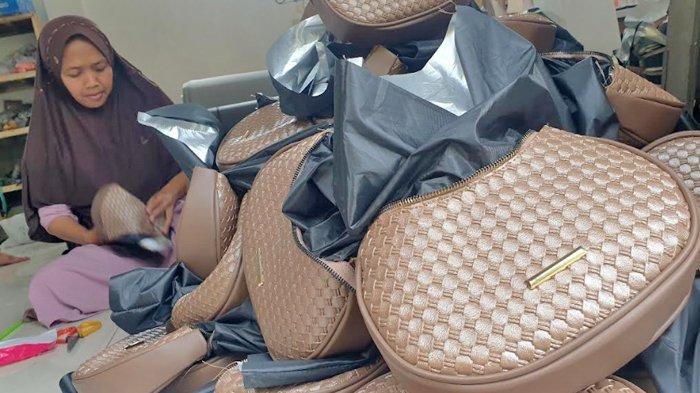 Perajin tas melakukan proses finishing di Sentra tas, Desa Kedungmaling, Kecamatan Sooko, Kabupaten Mojokerto.
