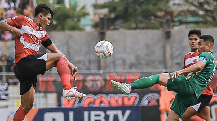 Reva Adi Utama saat berebut bola dengan M Fachruddin di laga Madura United vs Persebaya Surabaya