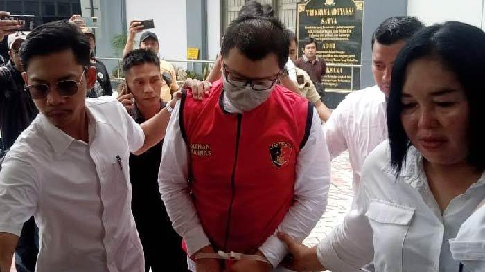 Ronald Tannur diapit dua penyidik berjalan masuk ke kantor Kejaksaan Negeri Surabaya, Senin (29/1/2024).