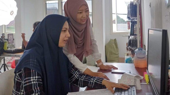 Yuni Retnowati (Kanan), pemilik toko online Topcarindo bersama dengan karyawan.