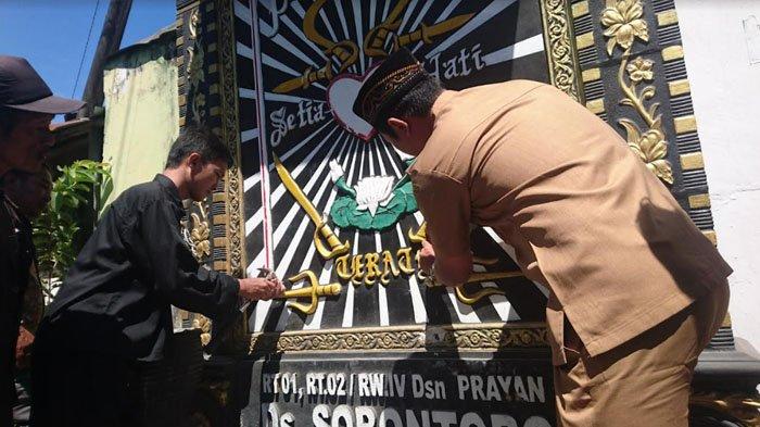 Tokoh PSHT mulai menghapus logo PSHT di tugu pencak silat yang ada di Dusun Karanggude, Desa Sobontoro, Kecamatan Boyolangu, Tulungagung, Senin (14/8/2023).