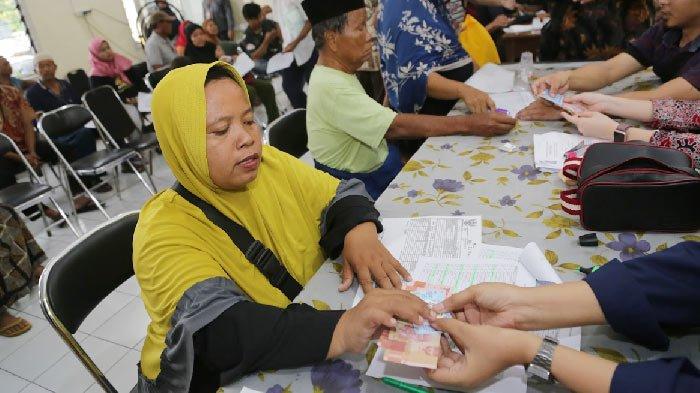Sejumlah warga saat menerima Bantuan Langsung Tunai (BLT) pengganti permakanan yang selama ini diterimakan berupa makanan jadi.