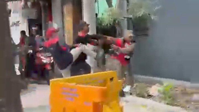 Tangkapan layar video saat petugas Satpol PP Kota Surabaya diserang saat rombongan buruh demo melintasi Jalan Ahmad Yani pada Kamis (30/11/2023) kemarin.