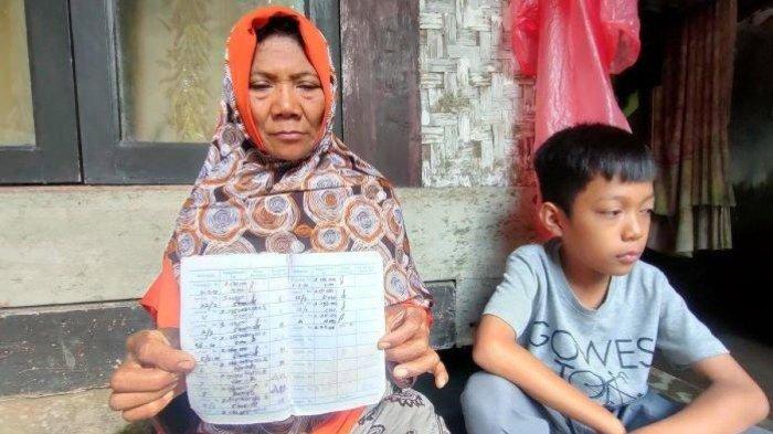 Armilah bersama anaknya memperlihatkan buku tabungan yang belum dikembalikan pihak sekolah di Pangandaran, Jumat (30/6/2023).