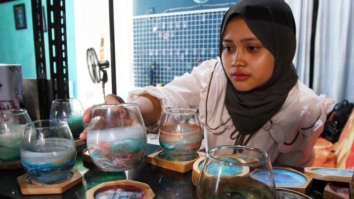 Pekerja menunjukan hasil karya Resin Epoxy di rumah produksi Catalis Decoration Malang, Jawa Timur, Selasa (13/8/2024).