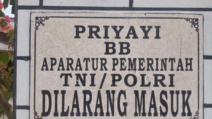 Plakat larangan masuknya pegawai yang terpasang di gapura masuk Dusun Setono