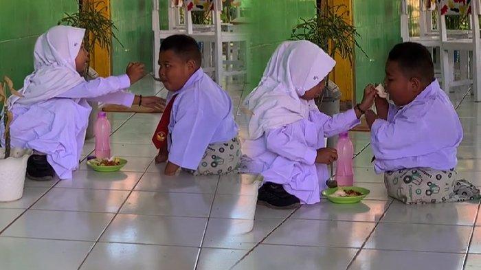 Reski disuapi temannya makan di SD Inpres Saluttowa, Sulawesi Selatan