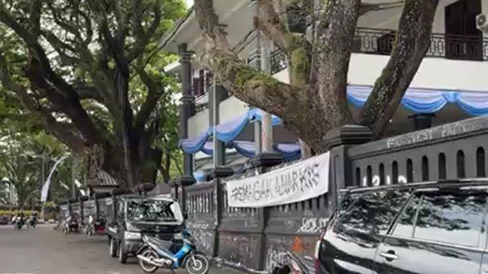 DEMO MALANG RICUH - Tampak dari luar gedung DPRD Kota Malang Senin (24/3/2025) pagarnya dipenuhi coretan bekas aksi pendemo Minggu (23/3/2025) malam. Tidak hanya di pagar, aspal jalan dan ukiran tulisan 