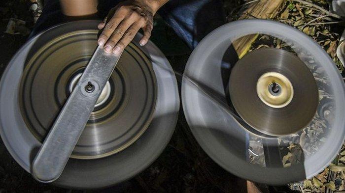 Teknisi menggulung ulang film 35mm untuk pemutaran film layar tancap