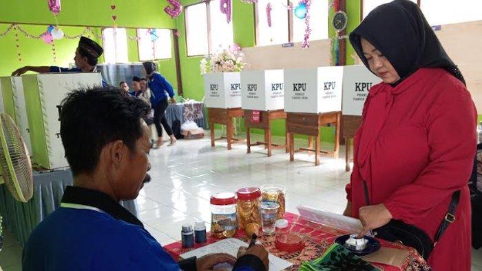 Warga mencelupkan jarinya ke tinta setelah mencoblos.