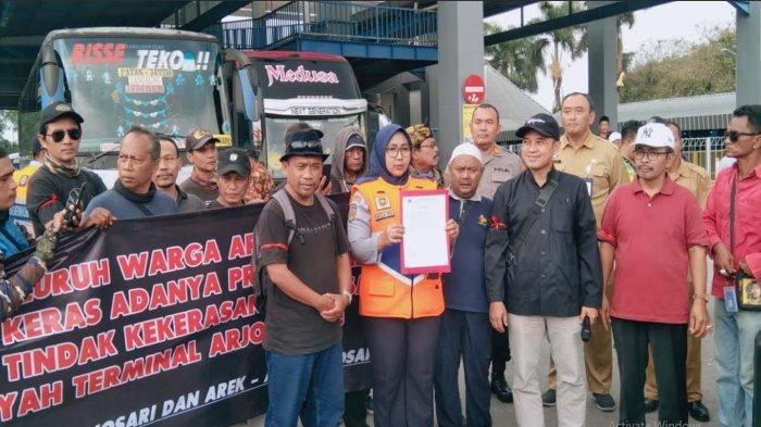 TOLAK PREMANISME - Kepala Terminal Arjosari, Mega Perwira Donowati bersama warga Arjosari saat membacakan tujuh poin nota kesepakatan bersama, Selasa (1/7/2025). Dalam kesepakatan bersama tersebut, salah satunya yaitu warga dan Terminal Arjosari sepakat menolak adanya aksi premanisme.