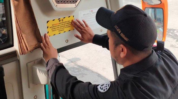 PELAKSANAAN SOSIALISASI - Petugas Terminal Arjosari Malang saat memasang stiker imbauan di dalam bus, Senin (9/6/2025). Diketahui hal ini dilakukan, sebagai bentuk sosialisasi aturan baru yang bakal diterapkan.
