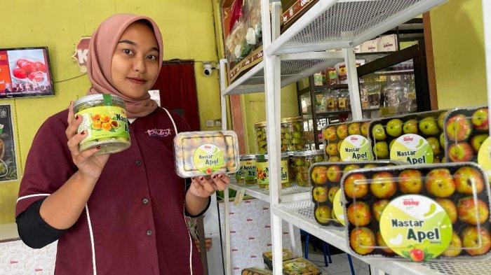 Pegawai menunjukan kue nastar apel yang dibuat di Toko Kue Obby, Kecamatan Dau, Kabupaten Malang, Senin (16/12/2024).