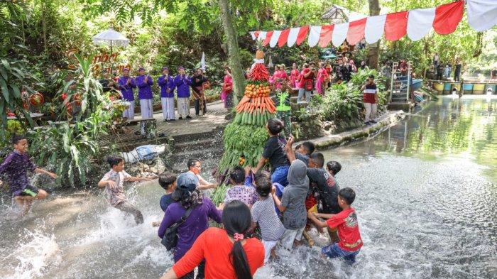 Gunungan berisi hasil bumi diusung masyarakat dalam Festival Sumber Banteng di Kelurahan Tempurejo, Kecamatan Pesantren, Kota Kediri, Minggu (27/11/2022).