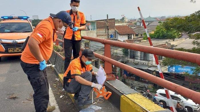 Tim Inafis Polrestabes Bandung melakukan olah tempat kejadian perkara pria tergantung dengan mata dan mulut dilakban di Flyover Cimindi, Kota Bandung.