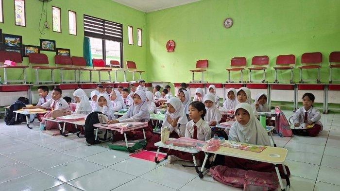 HARI PERTAMA SEKOLAH - Hari pertama masuk sekolah tahun ajaran 2025 - 2026 di SDN Kayuringin 16 Kota Bekasi, Kecamatan Bekasi Selatan, sejumlah siswa terpaksa harus duduk di lantai kelas karena kurangnya fasilitas kursi dan meja, Senin (14/7/2025). (TribunBekasi/RendyRutamaPutra).