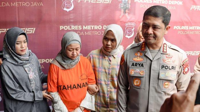 Mengenakan baju tahanan berwarna orange, celana hijau, sandal jepit merah, dan tangan yang tak diborgol, Meita Irianty hanya bisa menunduk saat polisi menggelar konferensi pers di Mako Polres Depok, Jalan Margonda, Kota Depok.