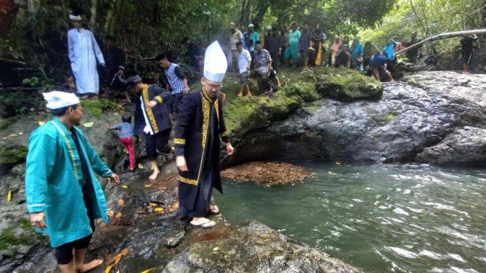 Tampak Sultan Bacan ke-22 Muhammad Irsyad Maulana Syah dan Bupati Halmahera Selatan Bassam Kasuba (menggunakan jubah hitam) berjalan di atas batu Talaga Boki. Warga Desa Boki Miake meminta jalan menuju Talaga Boki dibangun, Senin (24/6/2024).