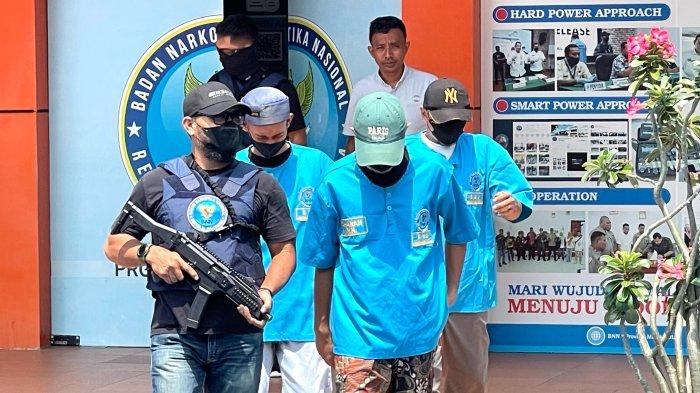 HUKUM: Tiga terduga pelaku penyalahgunaan narkotika dikawal anggota polisi saat keluar dari gedung BNN Maluku Utara, Kamis (12/6/2025).