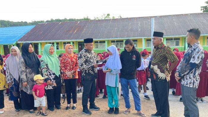 BANTUAN: Kepala Dinas Pendidikan Pulau Taliabu, Haruna Masuku serahkan langsung bantuan kepada dua siswi.