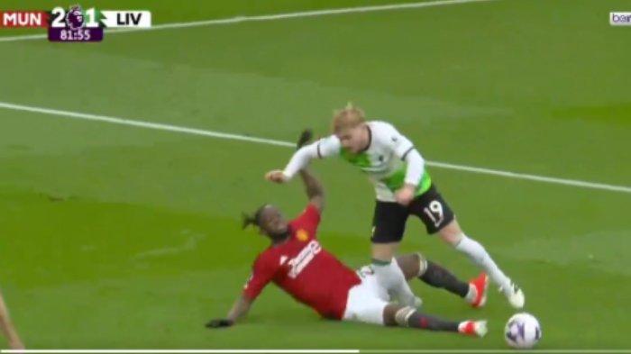 Pemain Manchester United Aaron Wan-Bissaka mencoba menekel pemain Liverpool Harvey Elliott.
