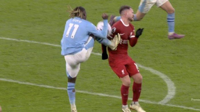 Tendangan tinggi Jeremy Doku mengenai dada Alexis Mac Allister saat pertandingan Liverpool vs Manchester City yang berakhir dengan  hasil imbang 1-1 dalam Matchday 28 Liga Premier, Minggu (10/3/2024) sore waktu setempat.