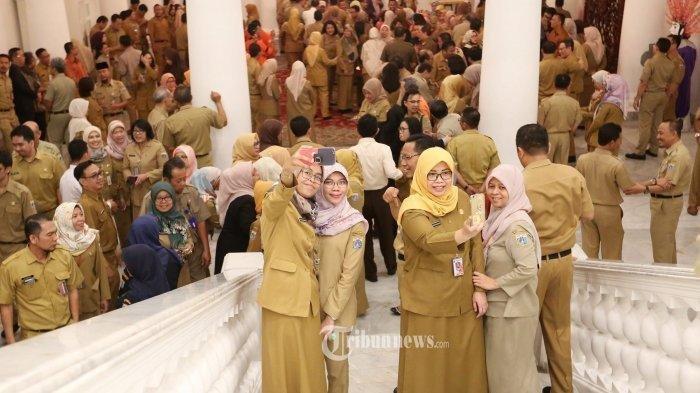 Sejumlah Pegawai Negeri Sipil (PNS) saat berselfie ditengah kerumunan pegawai saat acara halal bihalal dengan sejumlah Pegawai Negeri Sipil (PNS) di Gedung Balaikota, Jakarta Pusat, Senin (10/6/2019). Acara tersebut diikuti oleh ratusan pegaiwai balaikota Jakarta.