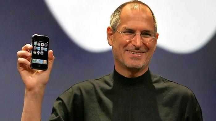 IPHONE PERTAMA - Steve Jobs memegang iPhone generasi pertama saat memperkenalkannya di ajang MacWorld di San Francisco, Amerika Serikat, 9 Januari 2007 silam. Apple selalu menempelkan waktu menunjukkan pukul 