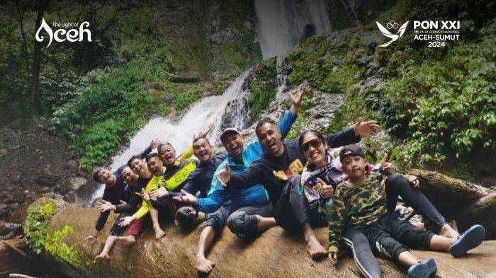 Pengunjung yang berfoto bersama dengan latar belakang pemandangan Air Terjun Jambor Latong.