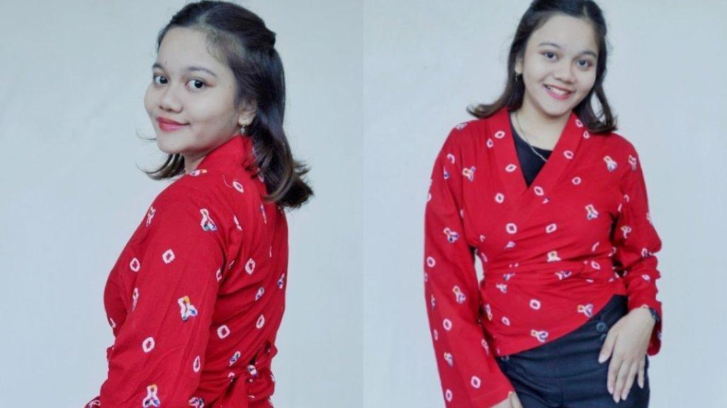 Atasan merah dari TLENIK Arts hadir dengan motif etnik dan potongan silang yang memberikan kesan feminin dan dinamis