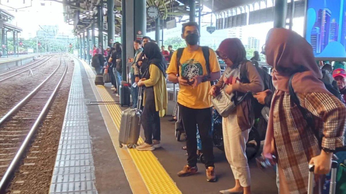 Ilustrasi para penumpang ketika menunggu kereta api yang hendak datang di stasiun.