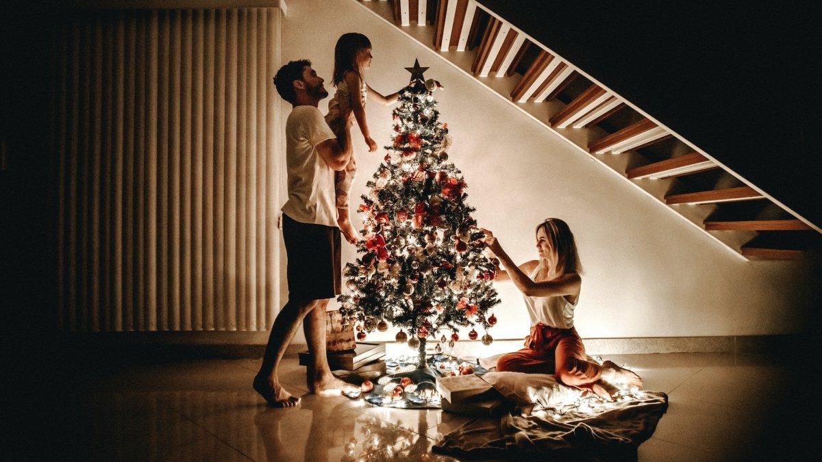 Ilustrasi keluarga yang menghiasi pohon Natal