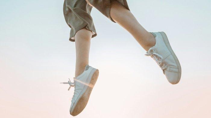 Ilustrasi seorang wanita memakai sepatu.