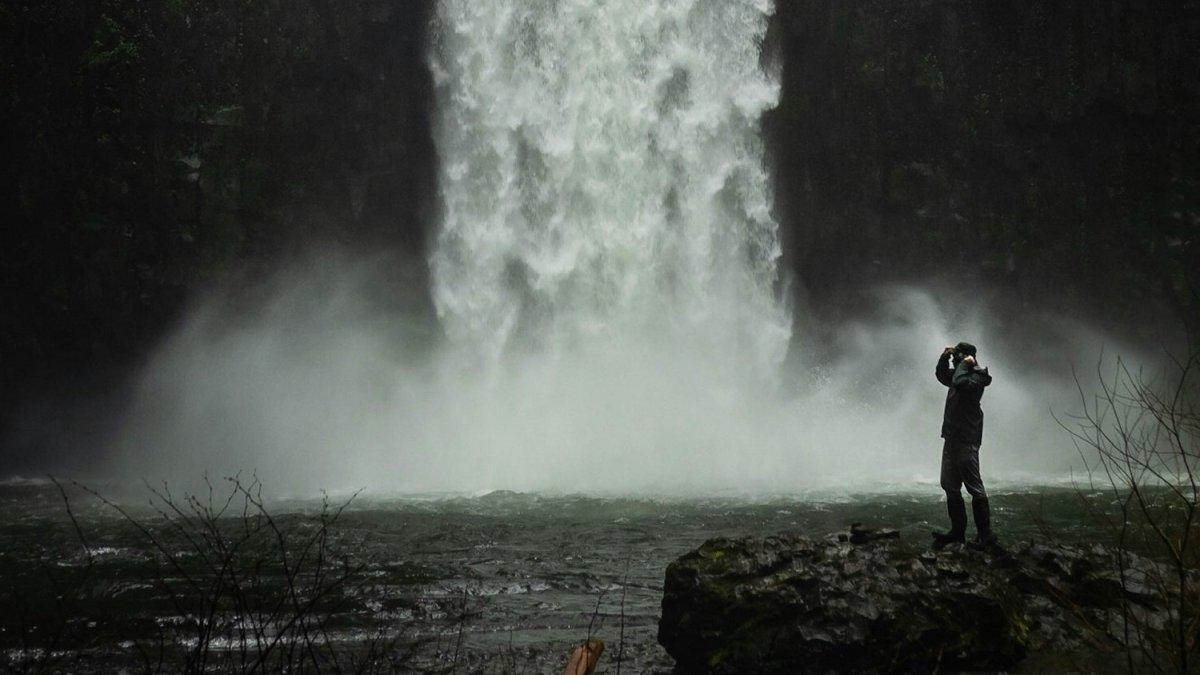 Ilustrasi wisatawan mengunjungi air terjun.