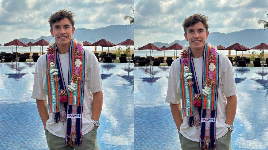 Marc Marquez memamerkan songket dan kalungan bunga yang ia dapatkan saat mendarat di Lombok.